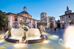 Square of Saint Mary's, fountain Rio Turia and cathedral in background at dusk in Valencia, Spain.